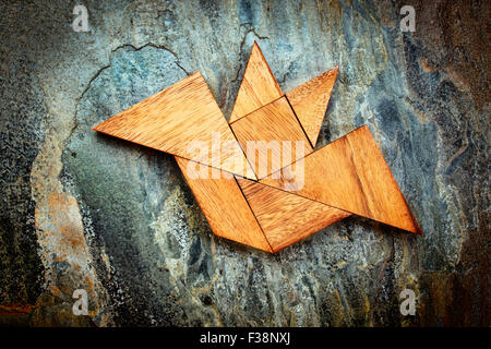 Résumé photo d'une chauve-souris volante construite à partir de sept pièces en bois tangram sur un rock fond ardoise, Halloween concept, artwork Banque D'Images