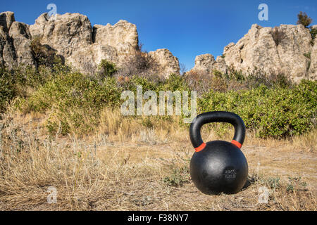 Concept de remise en forme en plein air - heavy iron kettlebell avec formations rocheuses en arrière-plan Banque D'Images