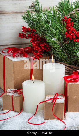 Décoration de Noël avec des bougies et des cadeaux. Les branches d'arbre de Noël aux fruits rouges Banque D'Images