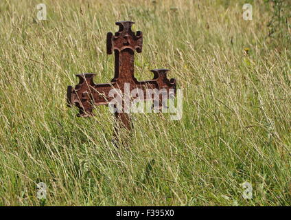 Croix de fer rouillé isolés à l'ancien cimetière dans Grass Field Banque D'Images