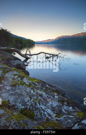 Le lever du soleil sur un calme plat le Loch Lomond. Banque D'Images