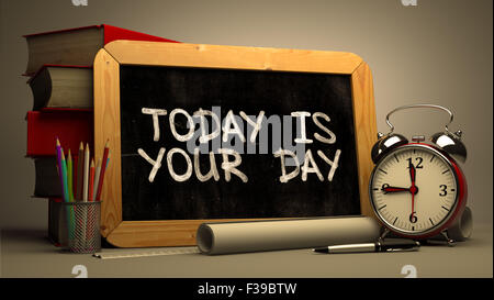 Citation de motivation - Aujourd'hui est votre jour - à la main sur tableau. Concept de temps. La composition avec tableau noir et pile de livres Banque D'Images