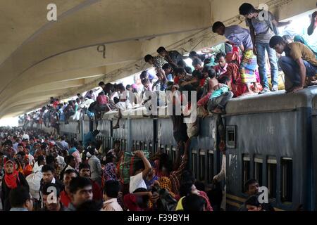 Les gens, y compris les enfants, descendre du toit d'un train entrant en gare de kamalapur à Dhaka le 1 octobre 2015.Comme il n'y avait pas de place à l'intérieur, ils ont voyagé sur le toit, risquent leur vie et leur intégrité physique pour revenir à la ville après les vacances de l'Aïd. Banque D'Images