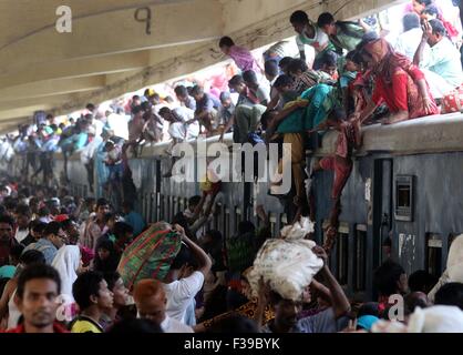 Les gens, y compris les enfants, descendre du toit d'un train entrant en gare de kamalapur à Dhaka le 1 octobre 2015.Comme il n'y avait pas de place à l'intérieur, ils ont voyagé sur le toit, risquent leur vie et leur intégrité physique pour revenir à la ville après les vacances de l'Aïd. Banque D'Images