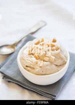 La crème glacée banane vegan fait maison (ici, à saveur de halva, avec tahina) servi avec des noix de cajou. Banque D'Images
