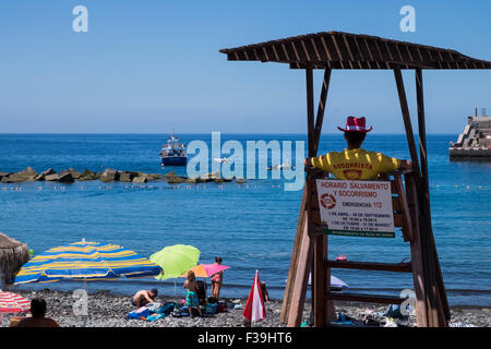 Femme lifeguard dans sa tour de guet sur la plage de Playa San Juan, Tenerife, Canaries, Espagne. Banque D'Images