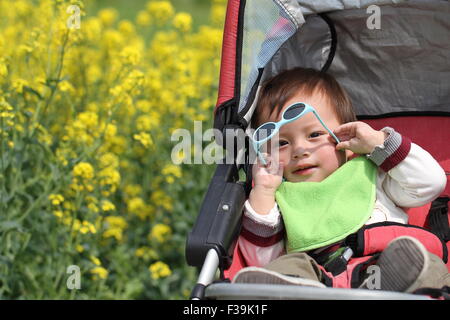 Tout-petits assis dans une poussette avec une paire de lunettes de soleil Banque D'Images