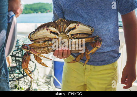 Boy holding freshly caught king crab Banque D'Images