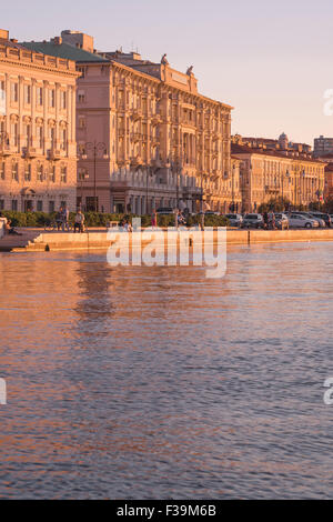Coucher de soleil sur le front de mer du port de Trieste, vue sur les bâtiments le long de la Riva del Madraccchio dans la zone centrale du front de mer de Trieste, Italie Banque D'Images