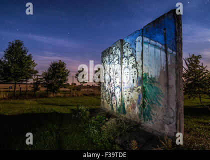 Petersdorf, Allemagne. 1 octobre, 2015. Dans la lueur d'un réverbère, les sections en béton du mur de Berlin dans la cour d'une galerie à Petersdorf, Allemagne, 1 octobre 2015. Pour afficher le tableau intitulé, 'Es geschah Novembre im( lt : Il s'est passé en novembre par l'artiste berlinois Iranien Kani Alavi. Le 3 octobre 2015 L'Allemagne s'est retrouvé pendant 25 ans. Photo : Patrick Pleul/dpa/Alamy Live News Banque D'Images