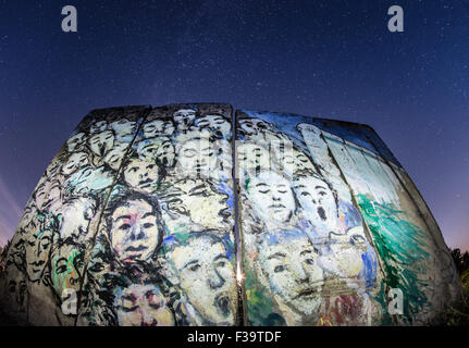 Petersdorf, Allemagne. 1 octobre, 2015. Dans la lueur d'un réverbère, les sections en béton du mur de Berlin dans la cour d'une galerie à Petersdorf, Allemagne, 1 octobre 2015. Pour afficher le tableau intitulé, 'Es geschah Novembre im( lt : Il s'est passé en novembre par l'artiste berlinois Iranien Kani Alavi. Le 3 octobre 2015 L'Allemagne s'est retrouvé pendant 25 ans. Photo : Patrick Pleul/dpa/Alamy Live News Banque D'Images