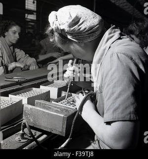 Années 1950, historique, femme opertative d'usine Contrôle de la tension à la British jamais co électrique, Dawley, Telford, l'Angleterre, les décideurs de la célèbre les batteries. Banque D'Images