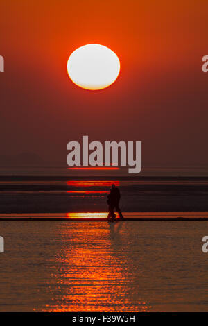 West Kirby, Wirral, Merseyside, Royaume-Uni. 2 octobre, 2015. Un couple en train de marcher sur le mur ouest du lac marin, Kirby, Wirral, Merseyside, passent devant le soleil couchant - Vendredi 2 Octobre 2014 Crédit : Damian Waters/Alamy Live News Banque D'Images