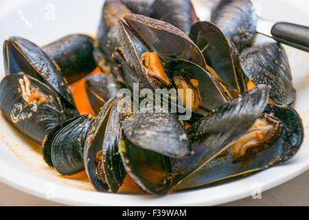 Un plat de moules des photos avec la sauce tomate, ouvert, prêt à manger, d'une table se propager. Banque D'Images