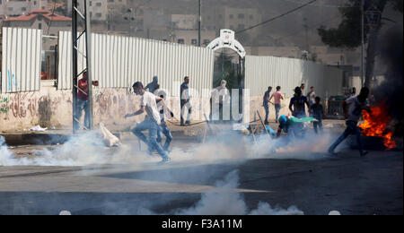 Des manifestants palestiniens Run for Cover en soldats israéliens (pas vu) incendie des gaz lacrymogènes dans les manifestants, dans la ville de Cisjordanie d'Hébron. Un jour après deux colons israéliens juifs ont été tués près de la ville cisjordanienne de Naplouse, le Hamas a appelé les Palestiniens à manifester pour la défense de la mosquée Al Aqsa. Dans la ville de Cisjordanie d'Hébron, les Palestiniens se sont rassemblés avec des drapeaux du Hamas et ont marché vers un poste de contrôle militaire israélien. L'escalade de la violence en Cisjordanie et Jérusalem Est capturé l'attention du monde entier après le président palestinien Mahmoud Abbas, a déclaré dans son discours aux Banque D'Images