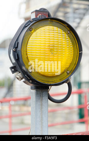 Un signal lumineux jaune sur un milieu urbain Banque D'Images