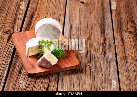 Fromage à croûte tendre blanc sur une planche à découper Banque D'Images