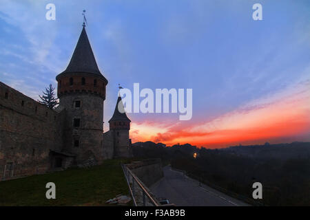 Coucher de soleil sur la tour médiévale du château en ruine à moitié à Kamenetz-Podolsk, Ukraine Banque D'Images