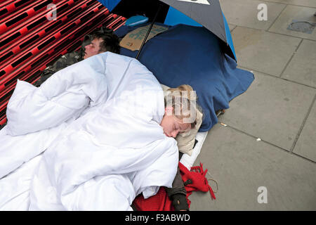 Deux jeunes pauvres sans-abri dorment dans la rue sur la chaussée à Bishopsgate London England UK KATHY DEWITT Banque D'Images