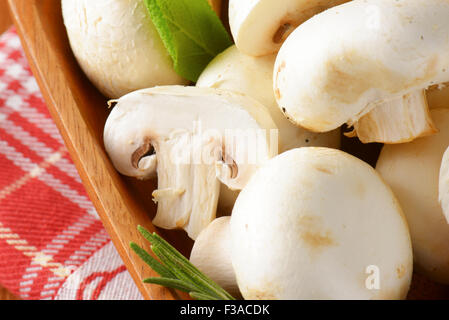 Champignons frais dans un bol en bois carré Banque D'Images