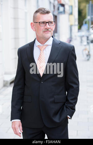 Portrait of businessman standing dans la rue portant des lunettes Banque D'Images