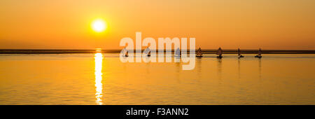 Des bateaux naviguant sur le lac marin Kirby de l'Ouest en face de soleil sur la rivière Dee, Wirral, Angleterre - Octobre Banque D'Images