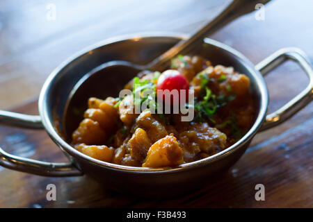 Plat végétarien indien Jeera Aloo ou pommes de terre indienne garnie de tomate Banque D'Images