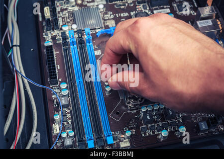 Une main est la fixation des composants de l'ordinateur Banque D'Images