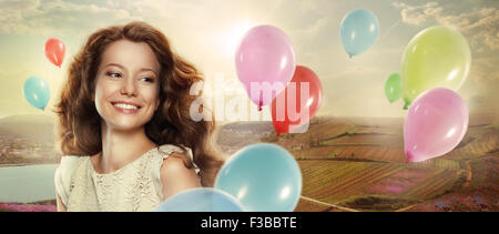 Maison de vacances. Femme heureuse avec des ballons colorés Banque D'Images