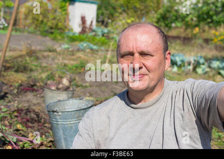 Portrait of a senior man making selfies première dans sa vie contre cuisine jardin Banque D'Images