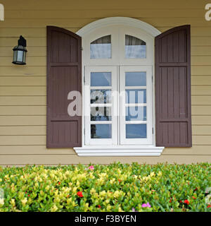 Vintage fenêtre sur mur en bois avec belle fleur Banque D'Images