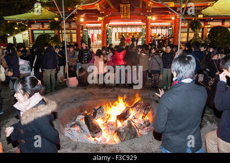 Nouvelle année, le Japon. Sanctuaire Shinto Nishinomiya. Les foules se rassemblent autour de feu où l'année précédente, bonne chance les charmes, Omamori, sont jetés dans. La nuit. Banque D'Images