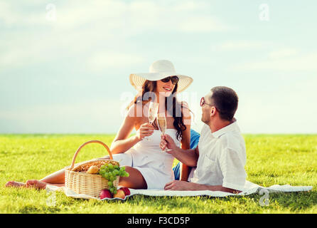 Smiling couple drinking champagne on picnic Banque D'Images