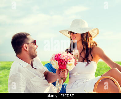 Smiling couple drinking champagne on picnic Banque D'Images