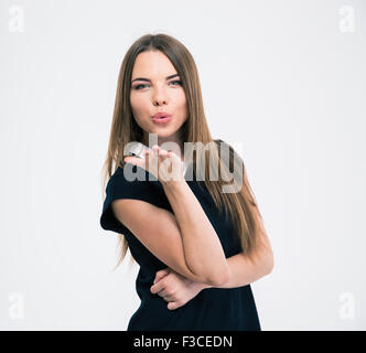 Portrait of a young cute woman blowing kiss à huis clos isolé sur un fond whiet Banque D'Images