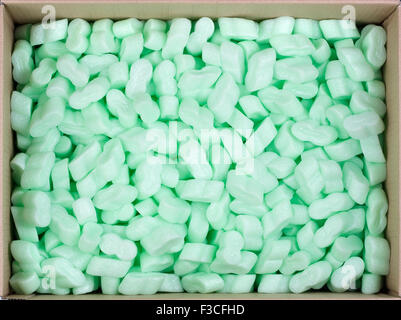 Boîte en carton des chapeaux est rempli de bulles de protection en plastique vert de granulés. Concept d'emballage sécuritaire. Vue d'en haut Banque D'Images