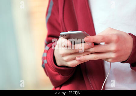 Jeune mâle adolescent using mobile phone Banque D'Images