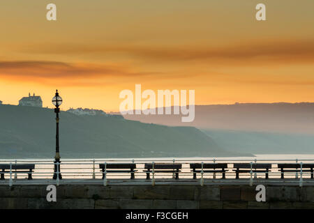 Coucher du soleil d'incandescence sur le West Pier à Whitby, North Yorkshire Coast, Octobre 2015 Banque D'Images