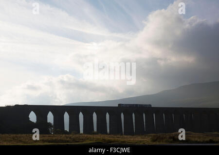 Passage d'un train ou Viaduc Ribblehead Viaduc Moss Batty porte le Settle-Carlisle Railway entre vallée de la rivière Ribble à Ribblehead, dans le Nord du Yorkshire, England, UK. Cette merveille d'architecture victorienne impressionnante a été conçu par l'ingénieur, John Crossley de Sydney et a été construit entre 1870 et 1874. Banque D'Images