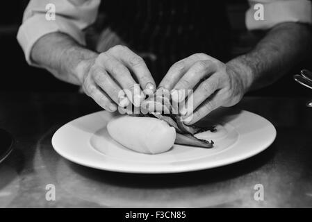 Restaurant chef de l'assemblage et de porc plat de pommes de terre Banque D'Images