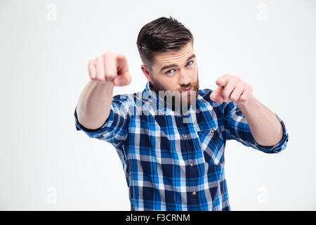 Portrait d'un bel homme pointer du doigt et isolée de l'appareil photo sur un fond blanc Banque D'Images