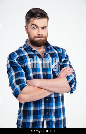 Portrait de stupéfié casual man standing with arms folded isolé sur fond blanc Banque D'Images