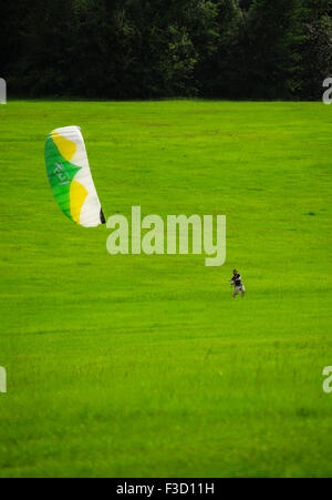 Test de l'homme son kite-surf compétences dans un grand champ. Banque D'Images