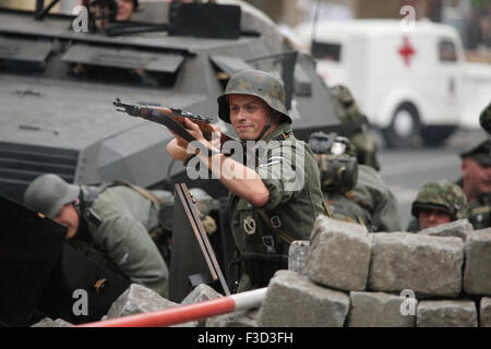 Comme en uniforme nazi allemand reconstitueurs soldats défendre une barricade au cours de la reconstitution de l'insurrection de Prague 1945 à Prague, en République tchèque, le 9 mai 2015. Banque D'Images
