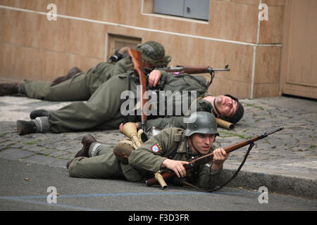 En tant que soldats en uniforme reconstitueurs de l'Armée de libération russe (OAK) assister à la reconstitution de l'insurrection de Prague 1945 à Prague, en République tchèque, le 9 mai 2015. L'Armée de libération russe également connu sous le nom de l'Armée de Vlasov est venu à l'aide de la République Tchèque Prague pour soutenir les insurgés soulèvement contre l'occupation allemande qui a débuté le 5 mai 1945. Banque D'Images