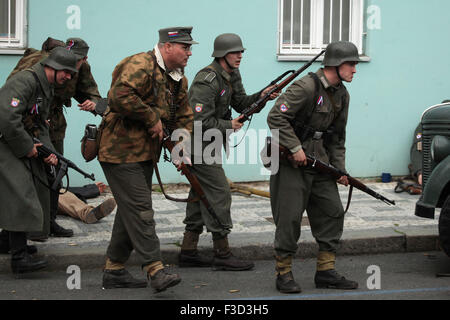 En tant que soldats en uniforme reconstitueurs de l'Armée de libération russe (OAK) assister à la reconstitution de l'insurrection de Prague 1945 à Prague, en République tchèque, le 9 mai 2015. L'Armée de libération russe également connu sous le nom de l'Armée de Vlasov est venu à l'aide de la République Tchèque Prague pour soutenir les insurgés soulèvement contre l'occupation allemande qui a débuté le 5 mai 1945. Banque D'Images