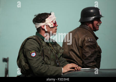 En tant que soldats en uniforme un reenactor de l'Armée de libération russe (OAK) fait semblant d'être blessés au cours de la reconstitution de l'insurrection de Prague 1945 à Prague, en République tchèque, le 9 mai 2015. L'Armée de libération russe également connu sous le nom de l'Armée de Vlasov est venu à l'aide de la République Tchèque Prague pour soutenir les insurgés soulèvement contre l'occupation allemande qui a débuté le 5 mai 1945. Banque D'Images