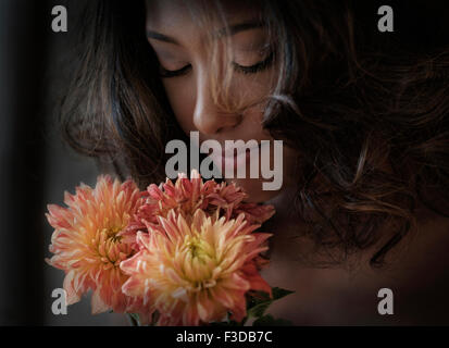 Young woman smelling flowers Banque D'Images