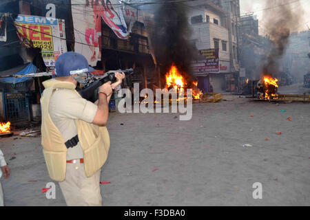 Varanasi, Inde. 05Th Oct, 2015. Un policier fire gaz lacrymogènes pour passionnés d'Hindu et sadhus pendant un meeting de protestation contre l'immerger les idoles Ganesha. Des centaines et des milliers de sadhus le lundi ont organisé une manifestation à Varanasi contre la police baton-charge sur un cortège où ils se dirigeaient à immerger Seigneur Ganesha's idol dans le Ganga. © Ravi Prakash/Pacific Press/Alamy Live News Banque D'Images