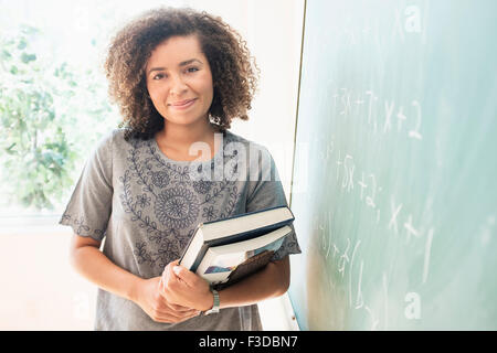 Portrait of young woman holding books Banque D'Images